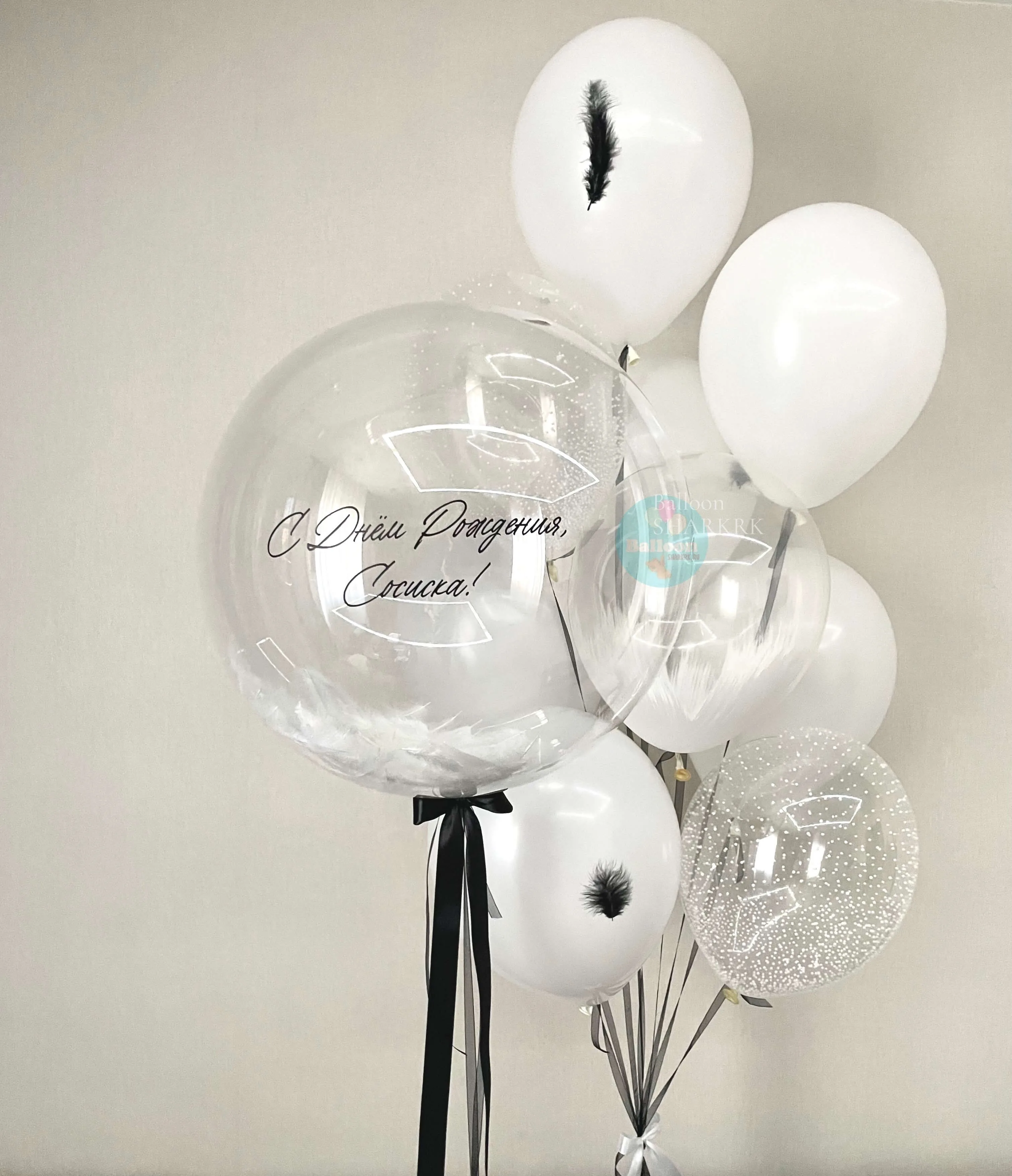 Белые шары с перьями и прозрачный шар с надписью